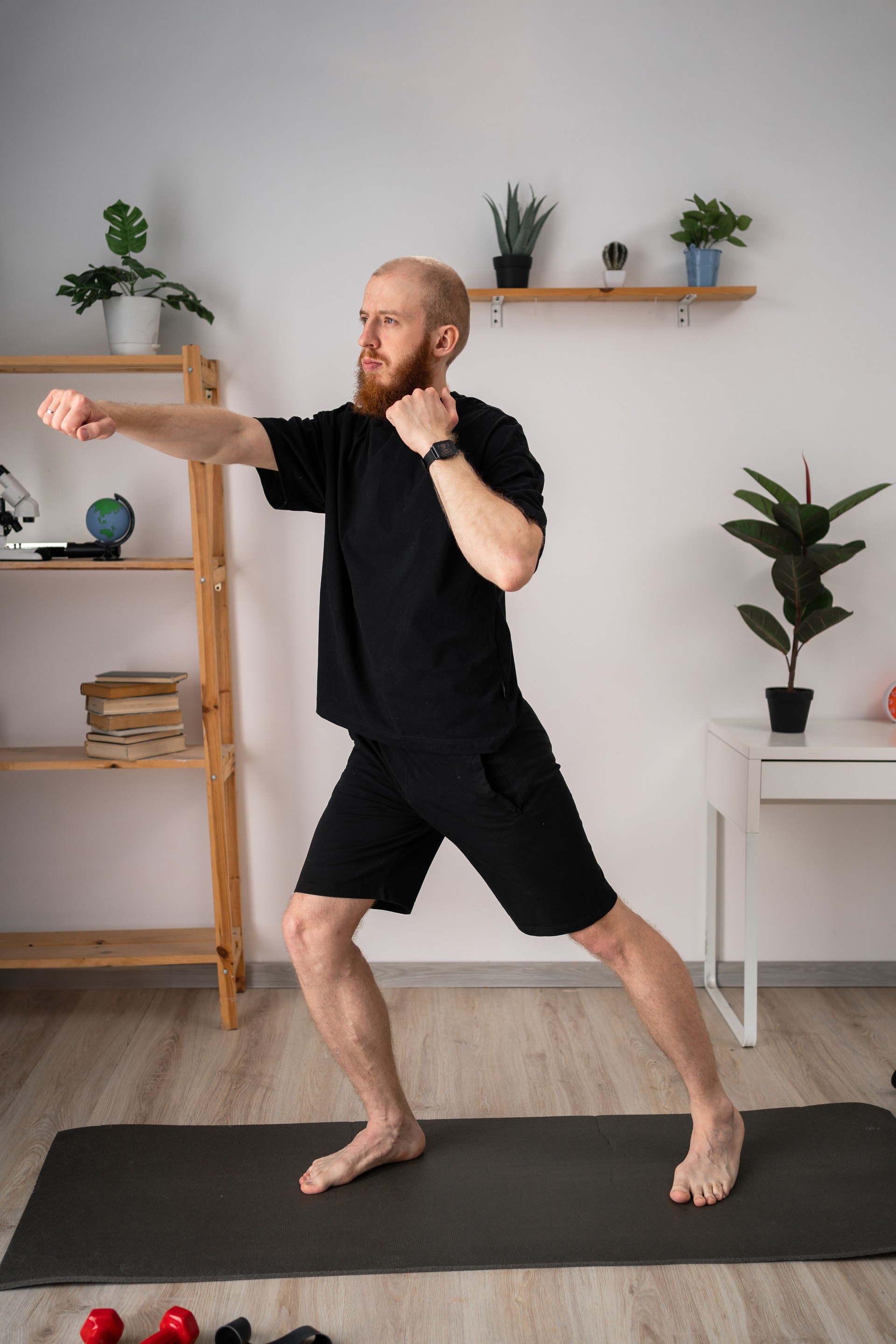 Junger männlicher Athlet boxt Schläge und macht zu Hause Sportübungen. Indoor-Fitness- und Sportkonzept
