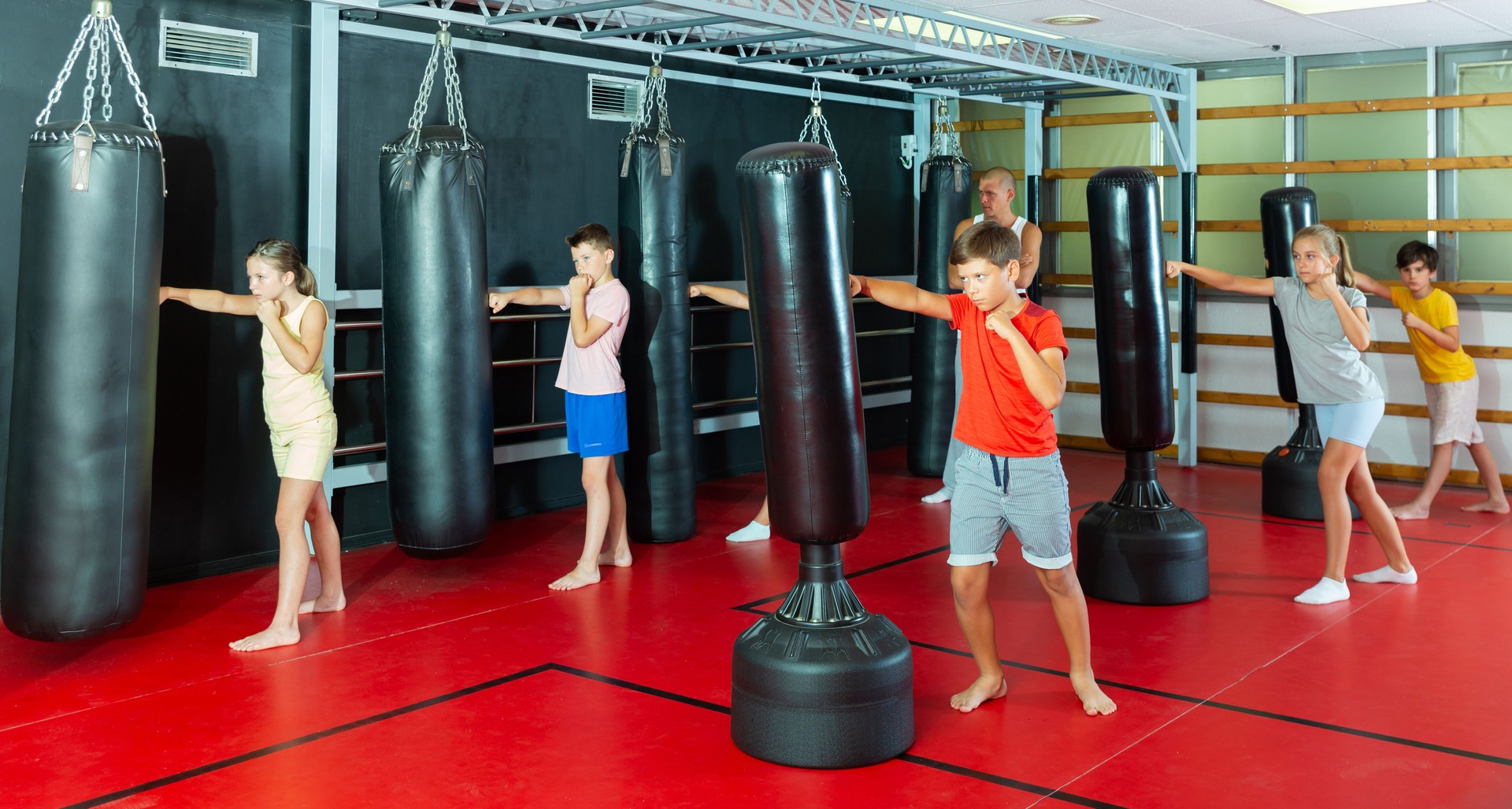 Kinder üben Schläge auf den Boxsäcken
