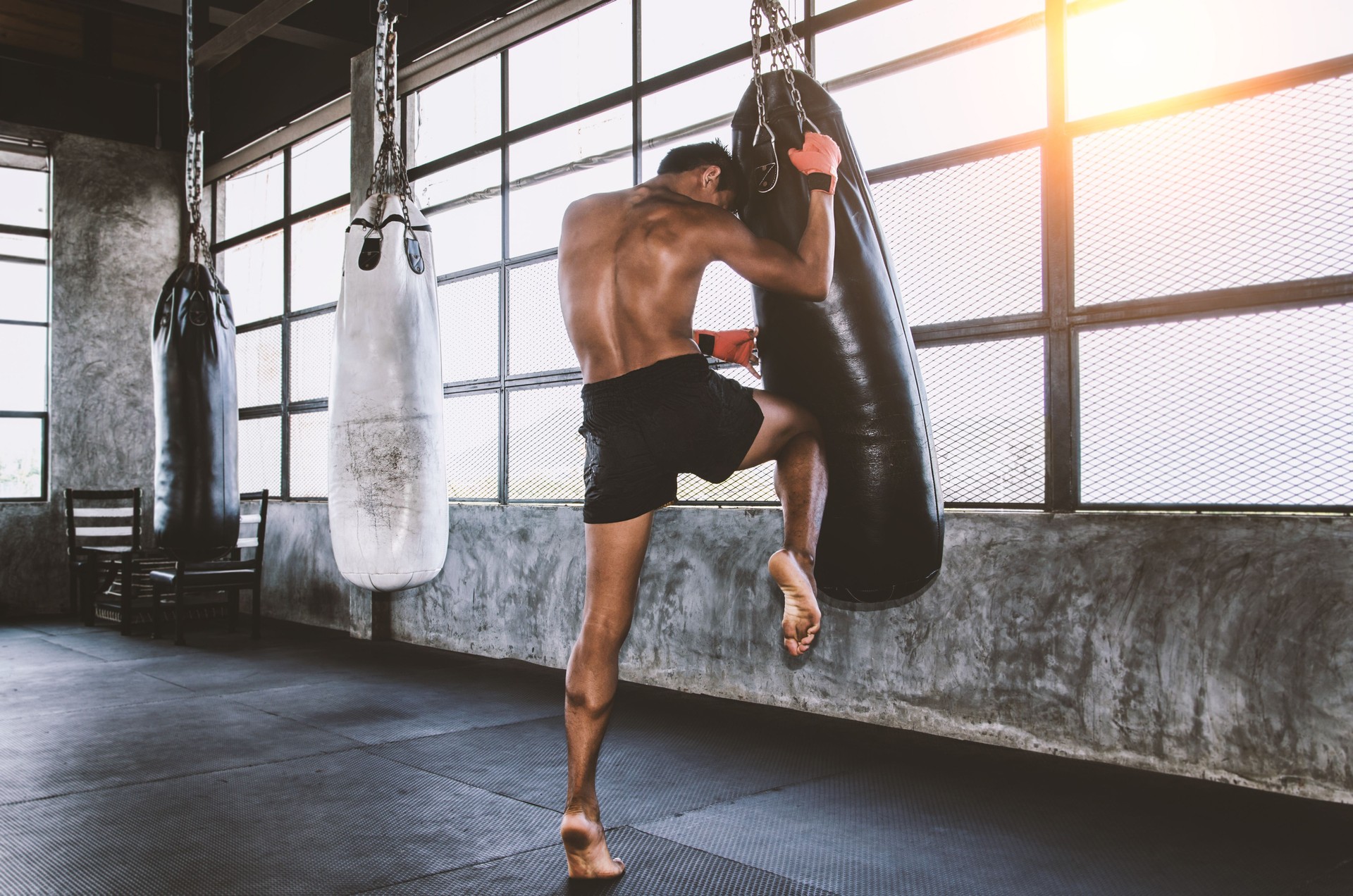 Muay thai Kämpfer Training in der Turnhalle mit dem Boxsack